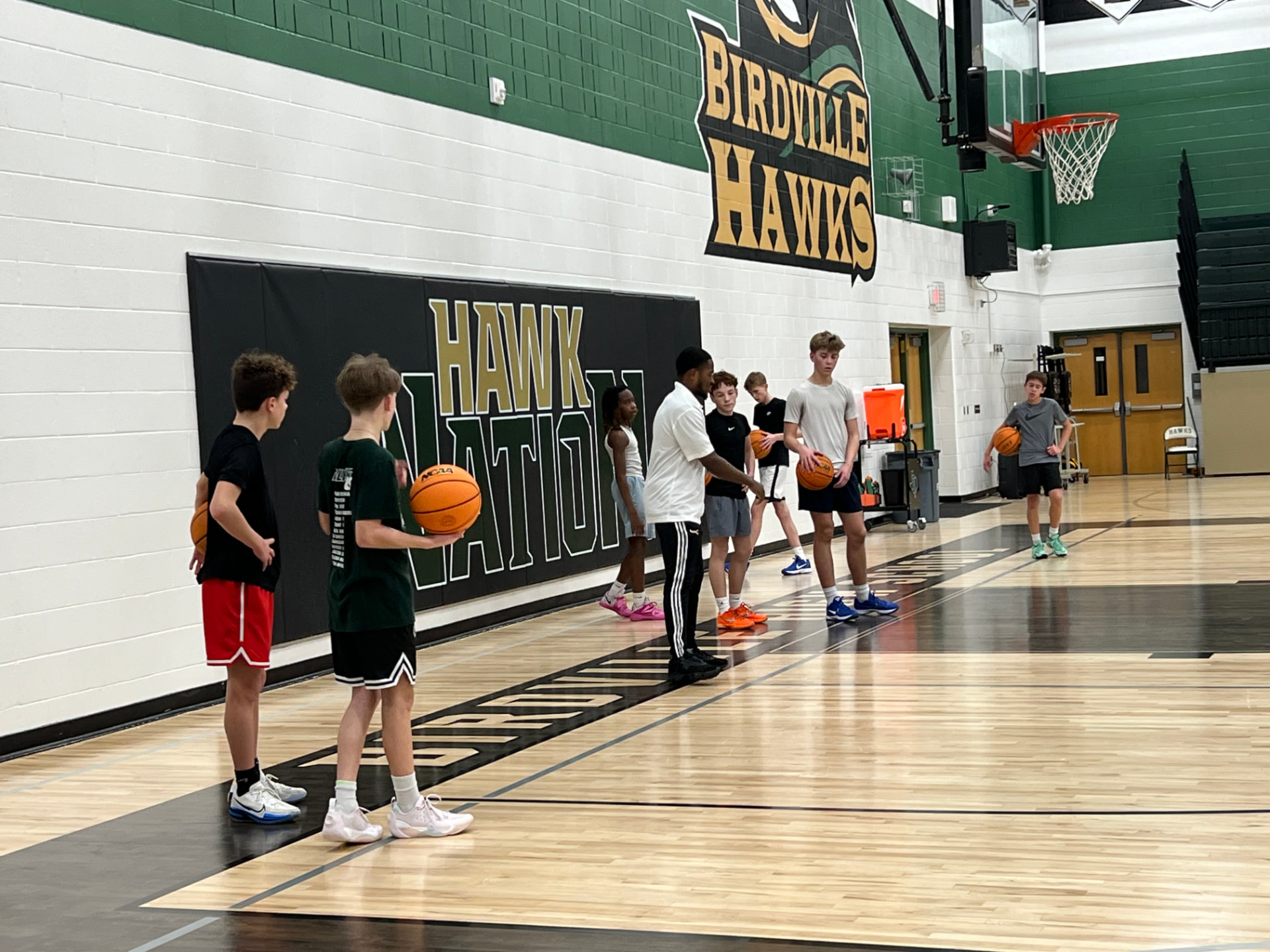 Jayhawks coach leading a shooting drill in the gym